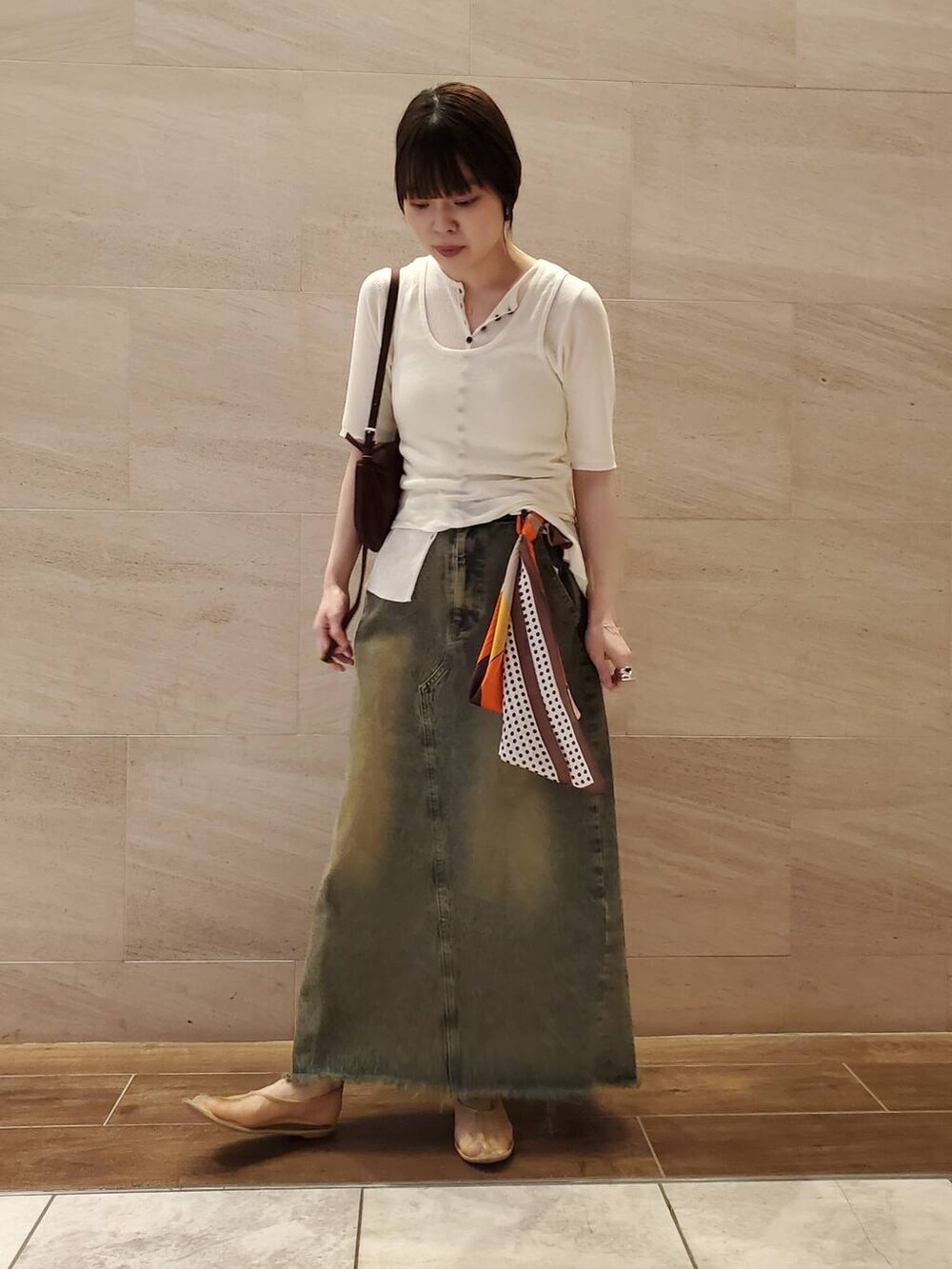 ブルー系のスカート、ホワイト系のニット/セーター、ブラウン系のバンダナ/スカーフを着用したレディースの夏コーディネートの2枚目の写真