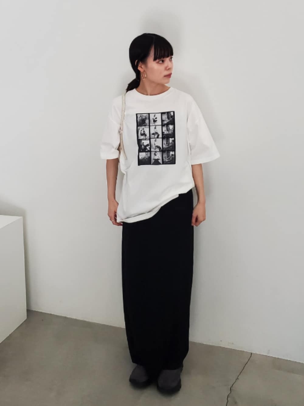 ホワイト系のTシャツ/カットソー、ブラック系のスカート、グレー系のスニーカーを着用したレディースの夏コーディネートの4枚目の写真