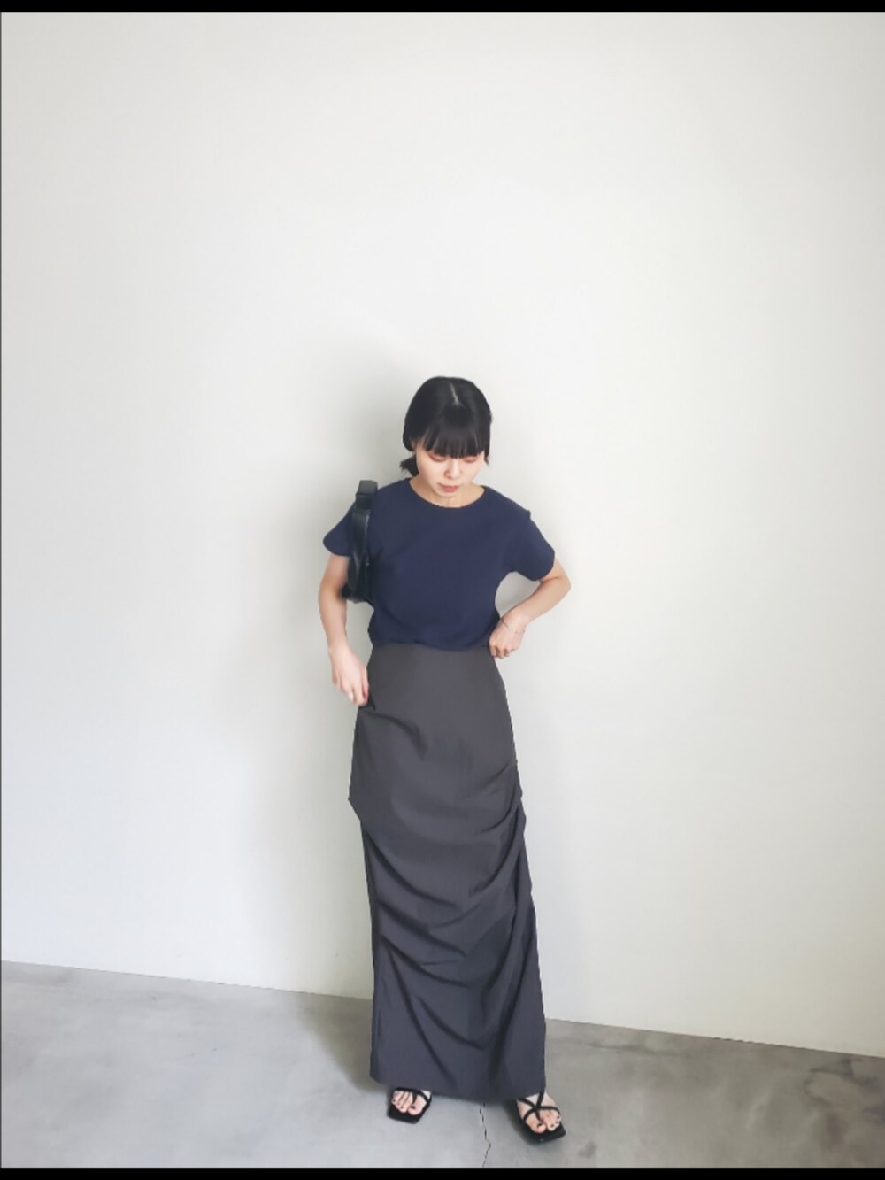 ブルー系のTシャツ/カットソー、ブラック系のスカート、ブラック系のショルダーバッグを着用したレディースの夏コーディネートの2枚目の写真