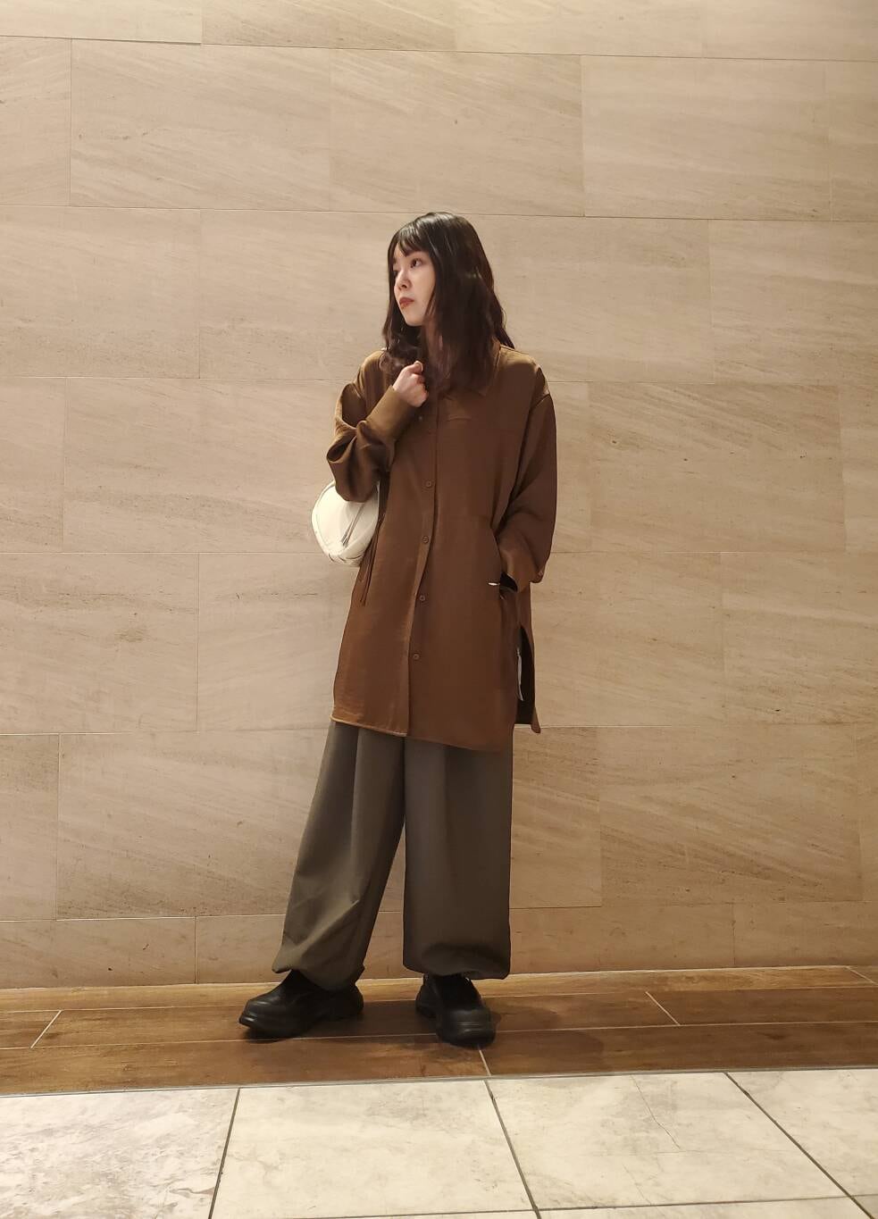 グリーン系のスラックス、ブラウン系のシャツ/ブラウスを着用したレディースの秋コーディネートの2枚目の写真