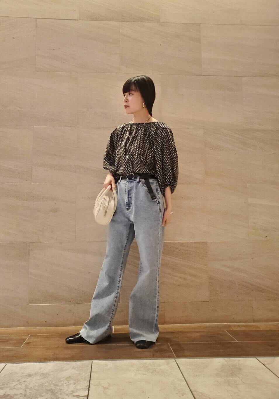 ブルー系のデニムパンツ、ブラック系のシャツ/ブラウスを着用したレディースの春コーディネートの2枚目の写真