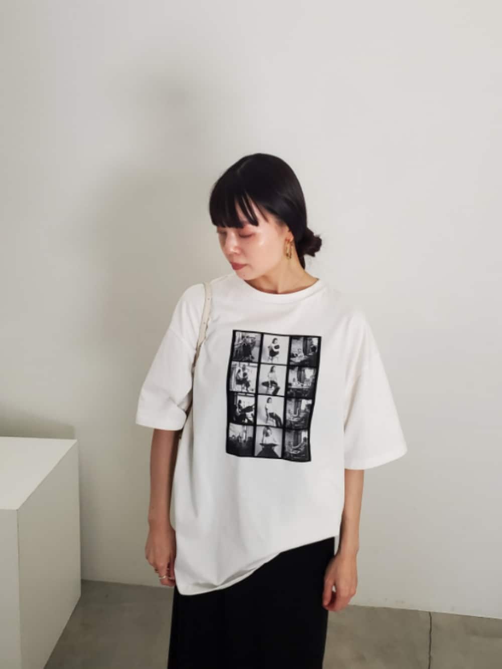 ホワイト系のTシャツ/カットソー、ブラック系のスカート、グレー系のスニーカーを着用したレディースの夏コーディネートの8枚目の写真