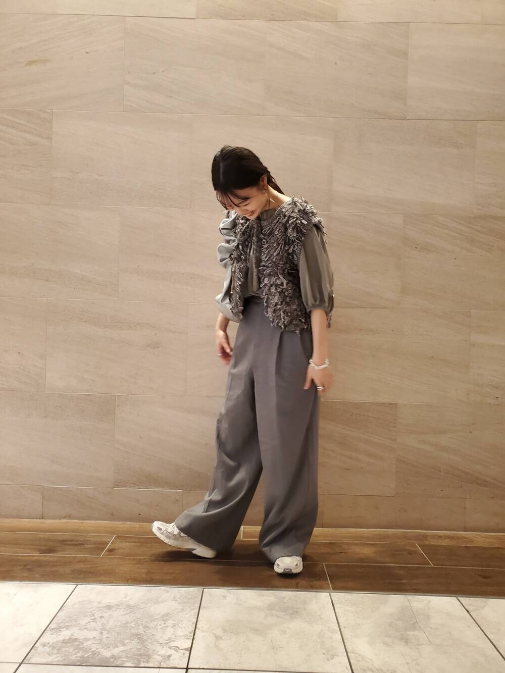 グレー系のベストを着用したレディースの夏コーディネートの2枚目の写真