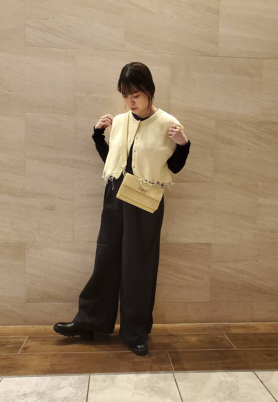イエロー系のベストを着用したレディースの秋コーディネートの3枚目の写真