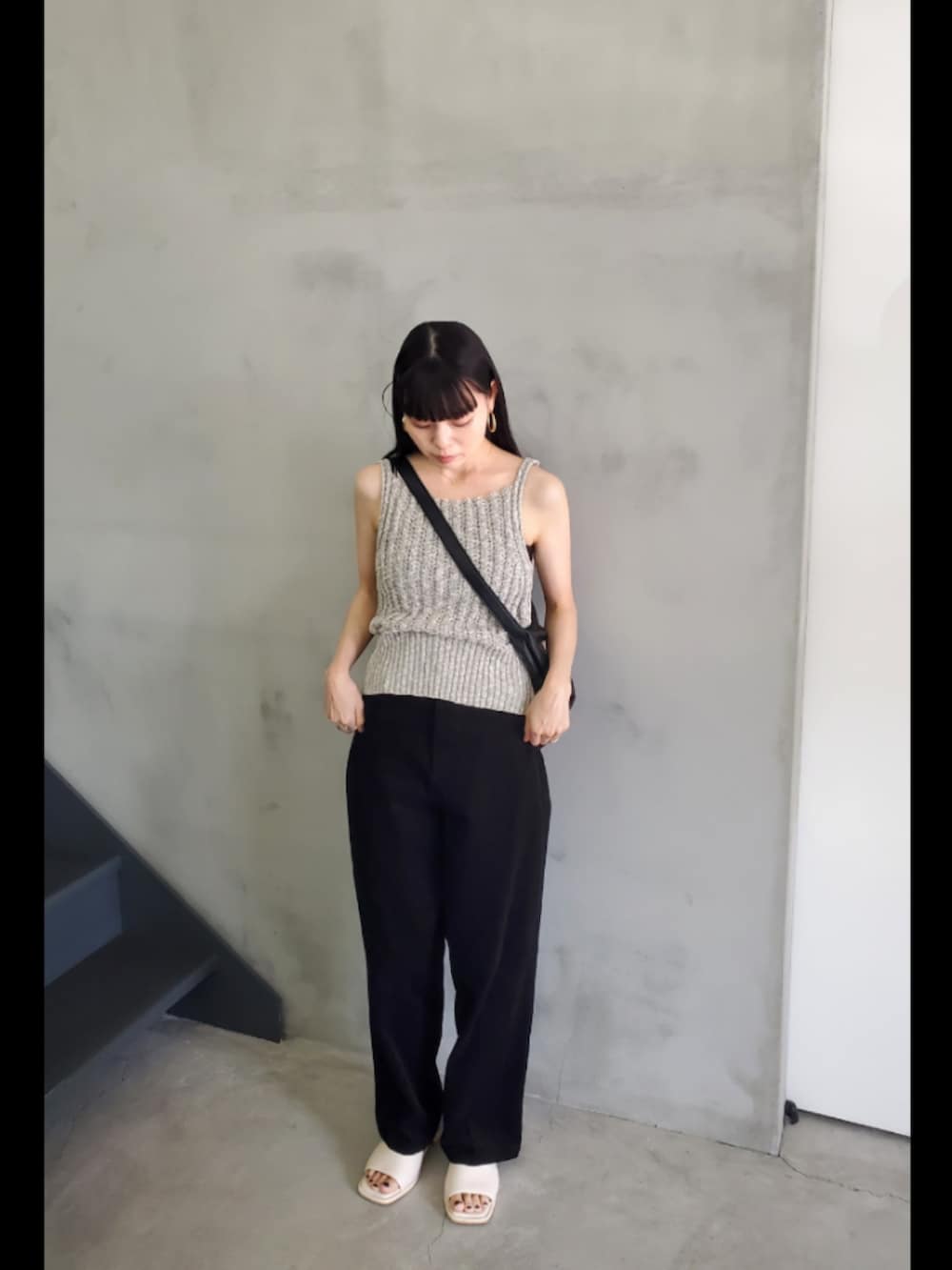 グレー系のベスト、ブラック系のその他パンツを着用したレディースの夏コーディネートの2枚目の写真