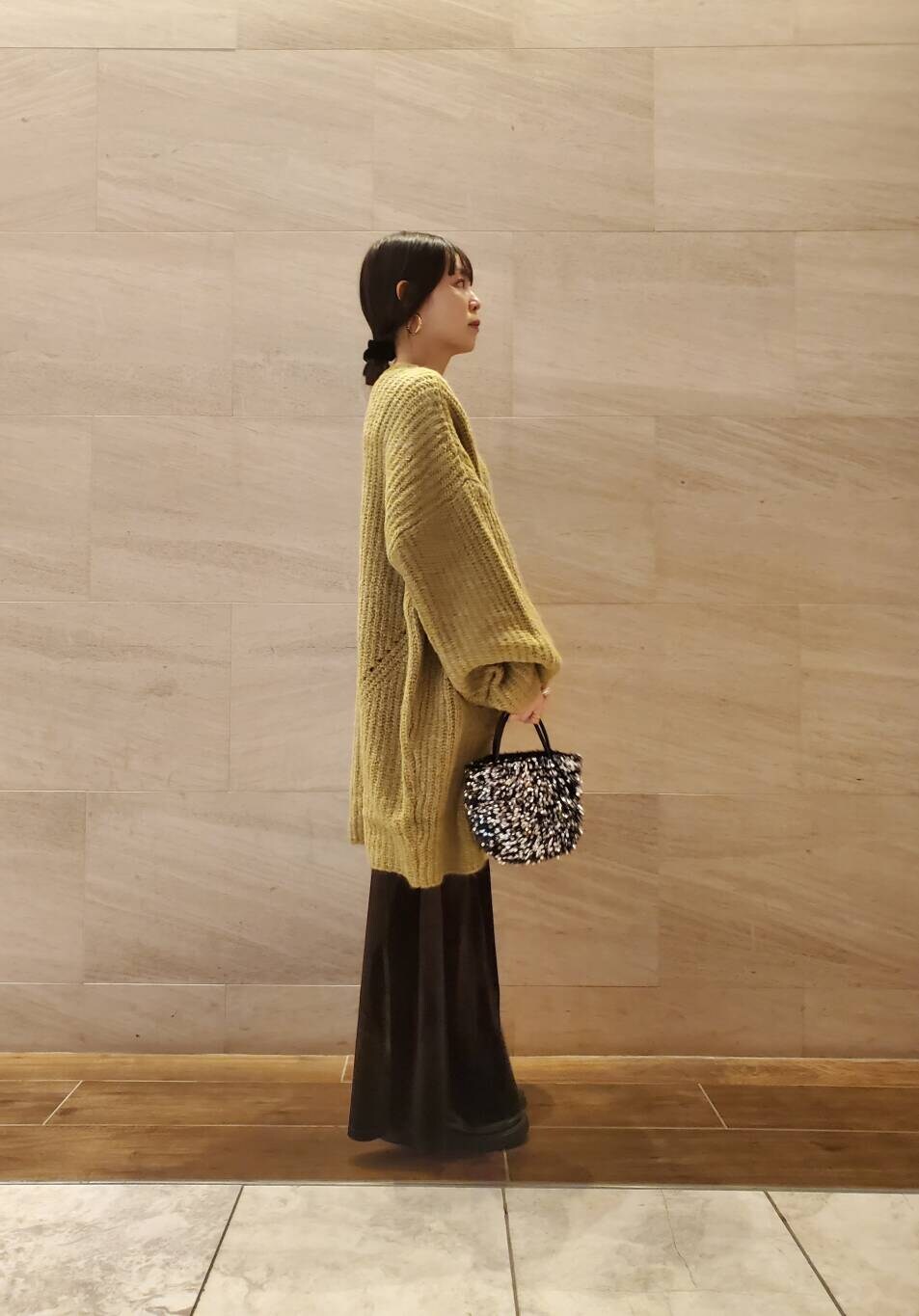 グリーン系のワンピース、ブラウン系のスカートを着用したレディースの冬コーディネートの4枚目の写真