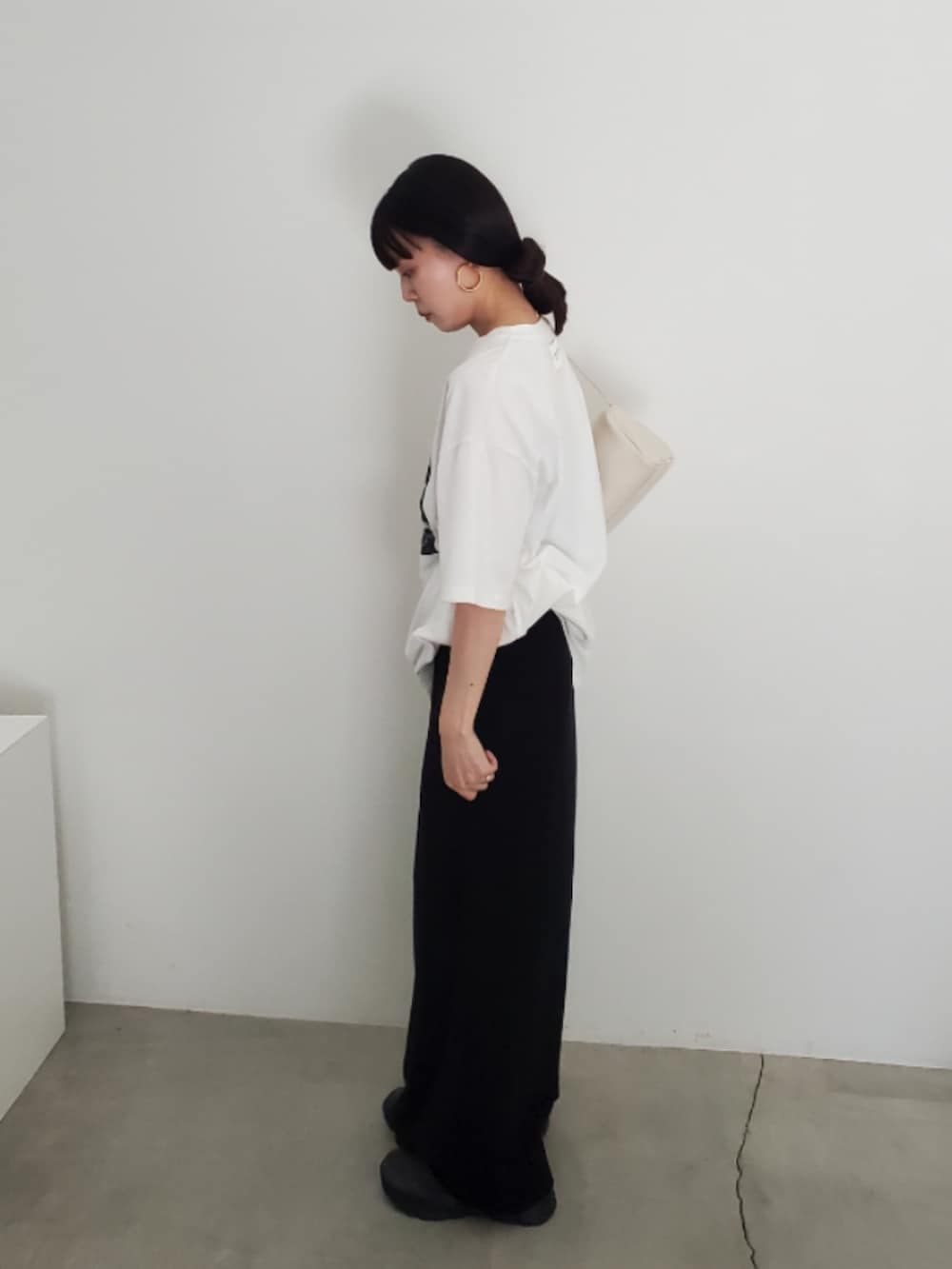 ホワイト系のTシャツ/カットソー、ブラック系のスカート、グレー系のスニーカーを着用したレディースの夏コーディネートの5枚目の写真