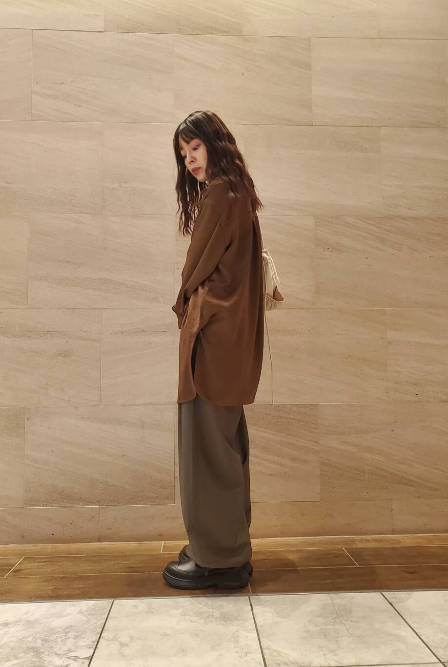 グリーン系のスラックス、ブラウン系のシャツ/ブラウスを着用したレディースの秋コーディネートの3枚目の写真