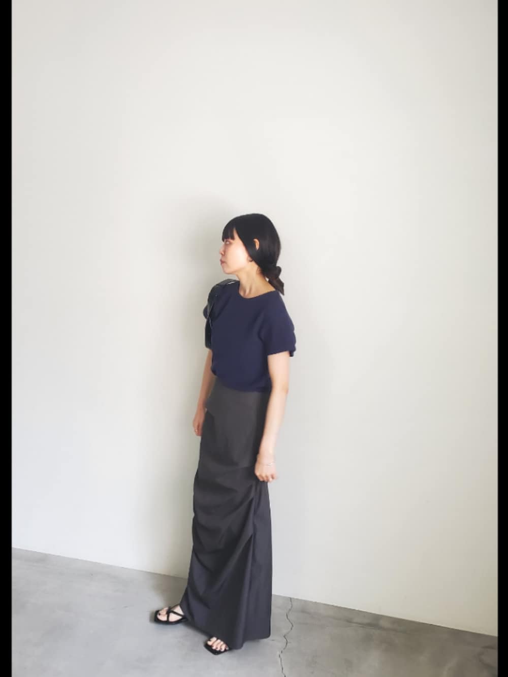 ブルー系のTシャツ/カットソー、ブラック系のスカート、ブラック系のショルダーバッグを着用したレディースの夏コーディネートの4枚目の写真