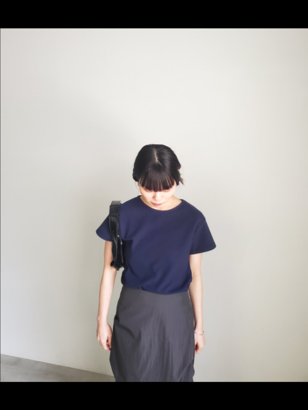 ブルー系のTシャツ/カットソー、ブラック系のスカート、ブラック系のショルダーバッグを着用したレディースの夏コーディネートの5枚目の写真