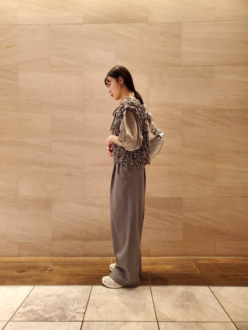 グレー系のベストを着用したレディースの夏コーディネートの3枚目の写真