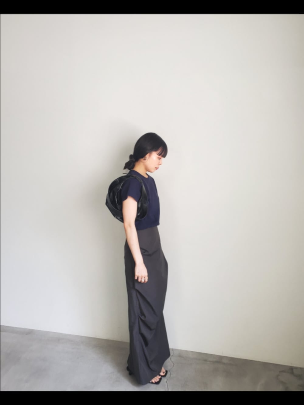 ブルー系のTシャツ/カットソー、ブラック系のスカート、ブラック系のショルダーバッグを着用したレディースの夏コーディネートの3枚目の写真