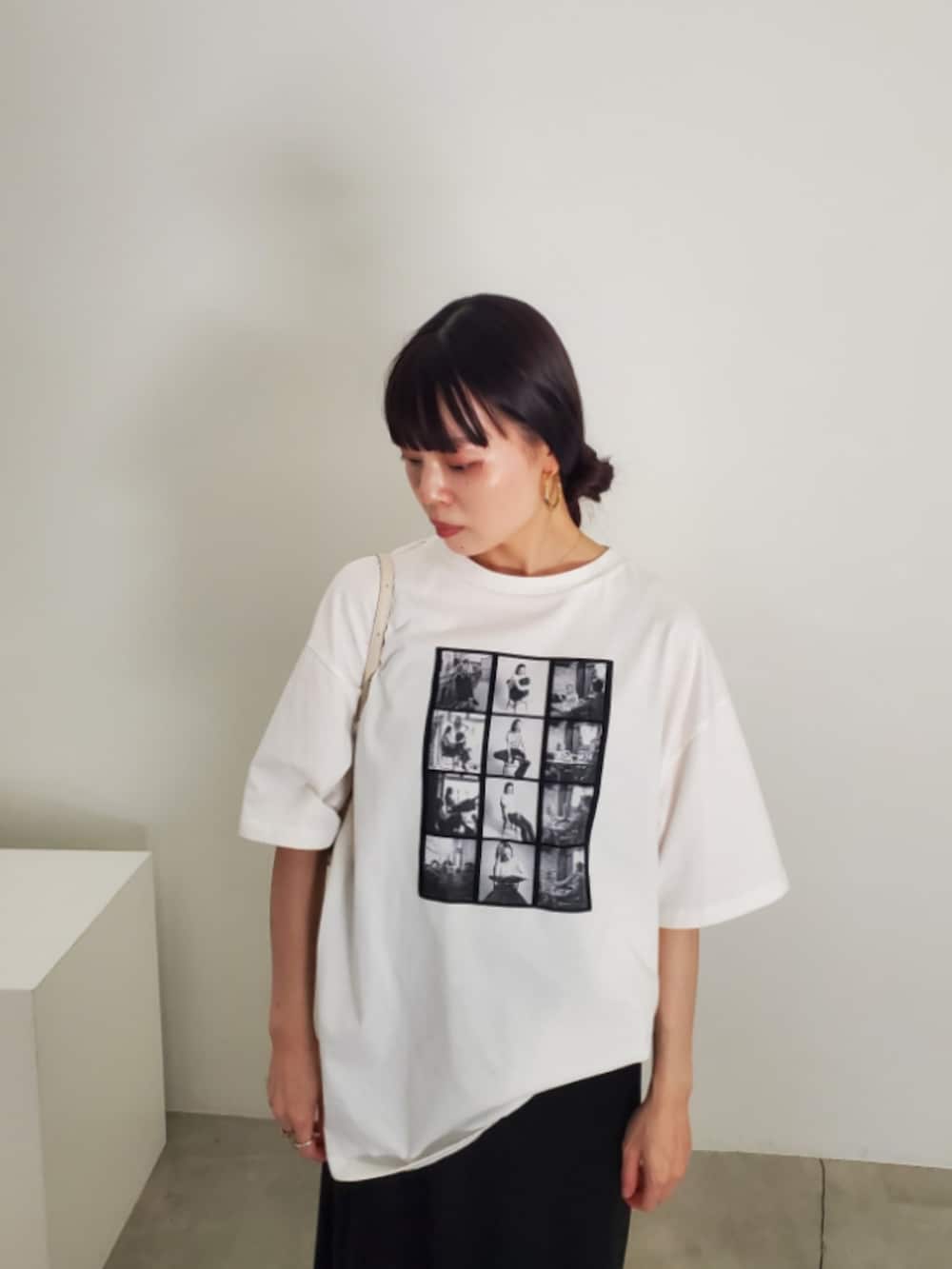 ホワイト系のTシャツ/カットソー、ブラック系のスカート、グレー系のスニーカーを着用したレディースの夏コーディネートの6枚目の写真