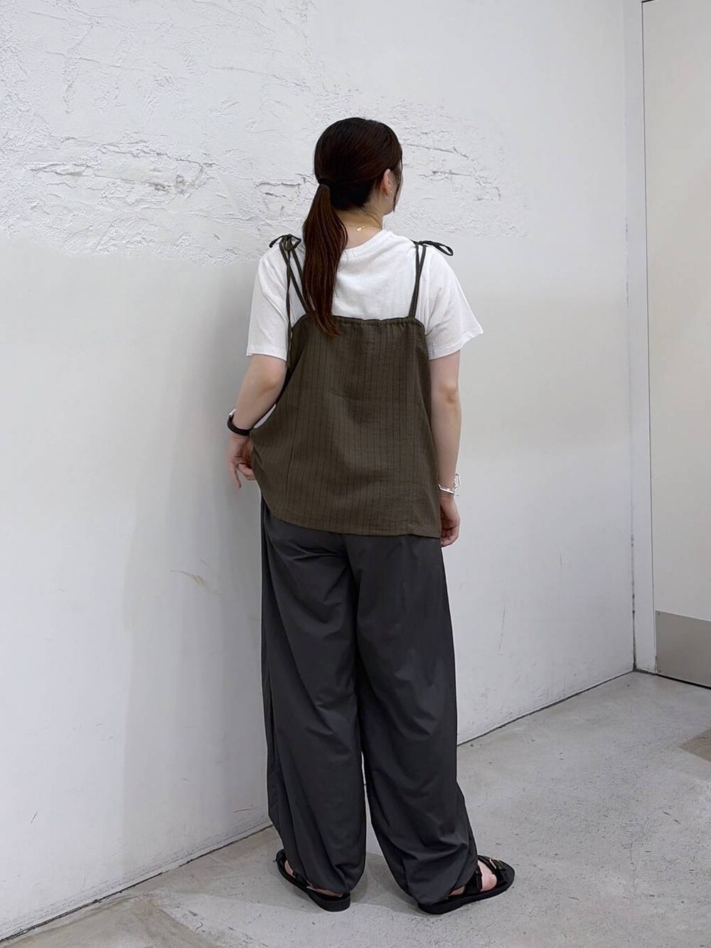 ブラック系のサンダル、グレー系のその他パンツ、グリーン系のキャミソールを着用したレディースの夏コーディネートの4枚目の写真