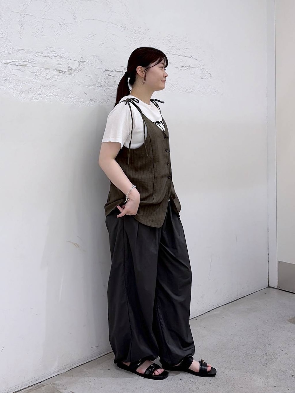 ブラック系のサンダル、グレー系のその他パンツ、グリーン系のキャミソールを着用したレディースの夏コーディネートの3枚目の写真