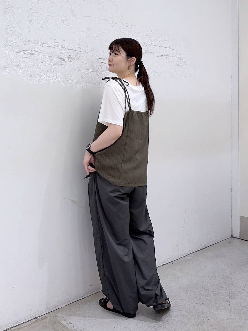 ブラック系のサンダル、グレー系のその他パンツ、グリーン系のキャミソールを着用したレディースの夏コーディネートの2枚目の写真