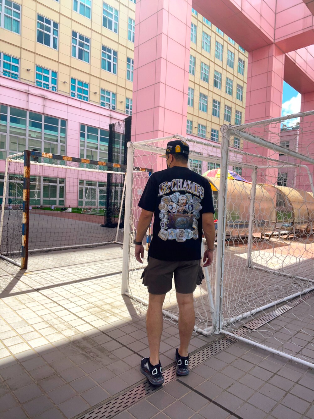 ブラック系のTシャツ/カットソー、ブラウン系のカーゴパンツ、ブラック系のスニーカーを着用したメンズの冬コーディネートの2枚目の写真