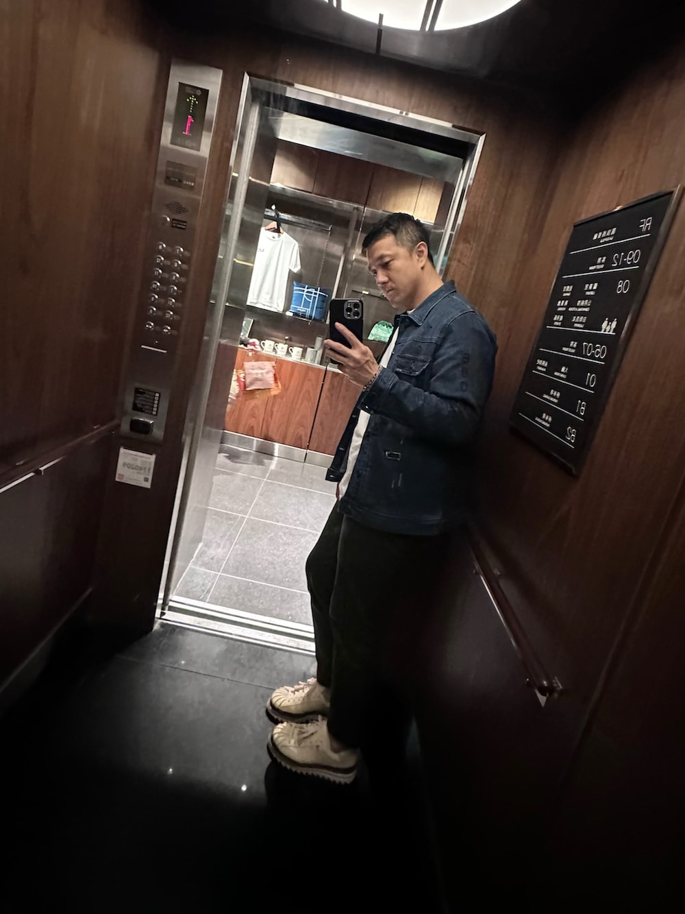 ホワイト系のTシャツ/カットソー、ブルー系のデニムジャケット、グリーン系のチノパンツを着用したメンズの冬コーディネートの2枚目の写真