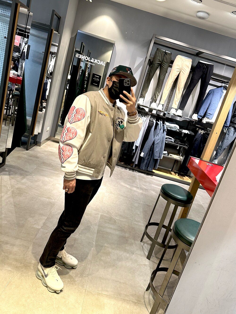 グレー系のスタジャン、ブラック系のデニムパンツ、ブラック系のスニーカーを着用したメンズの冬コーディネートの3枚目の写真