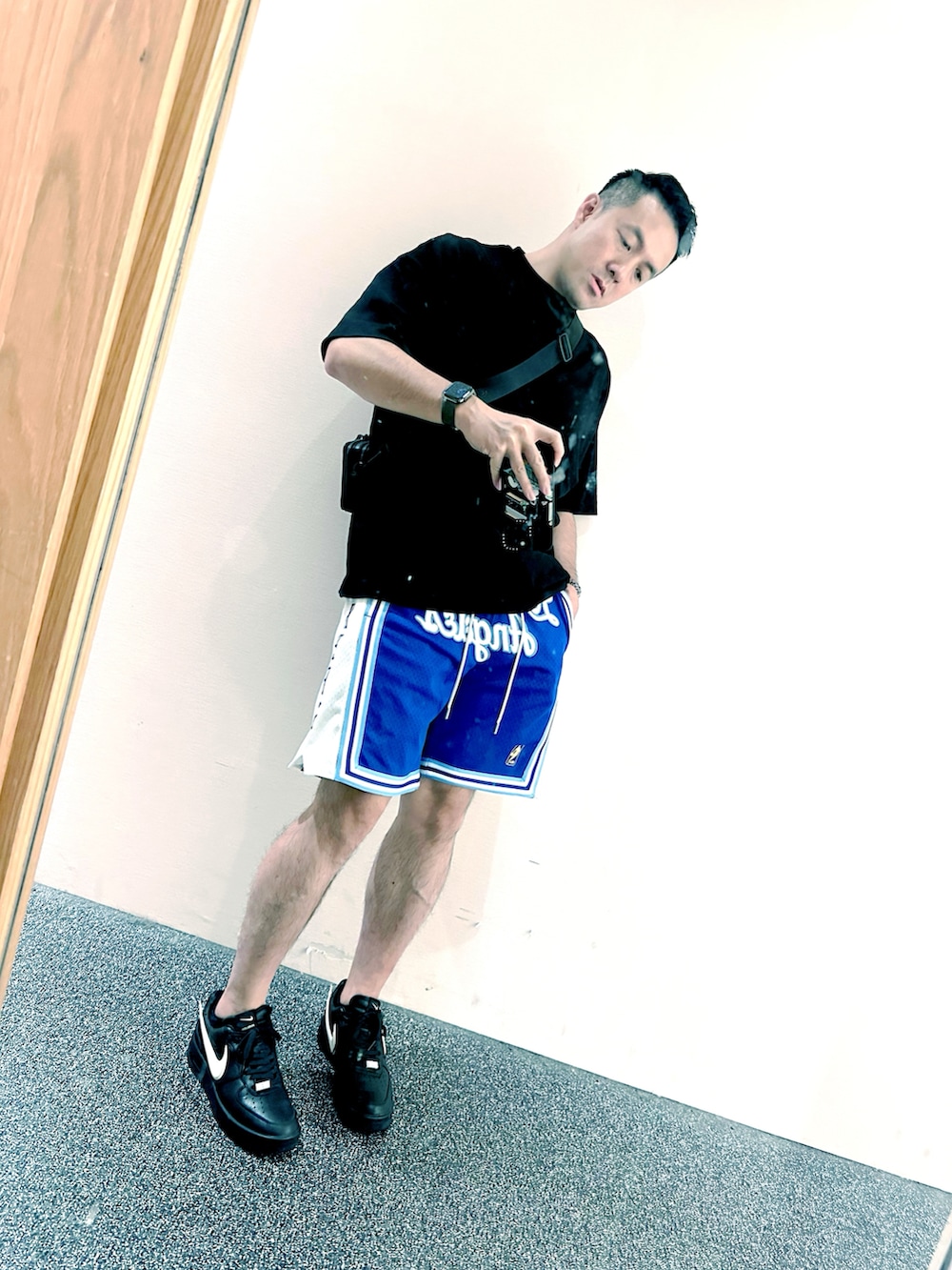 ブラック系のTシャツ/カットソー、ブラック系のショルダーバッグ、ブルー系のカーゴパンツを着用したメンズの冬コーディネートの2枚目の写真