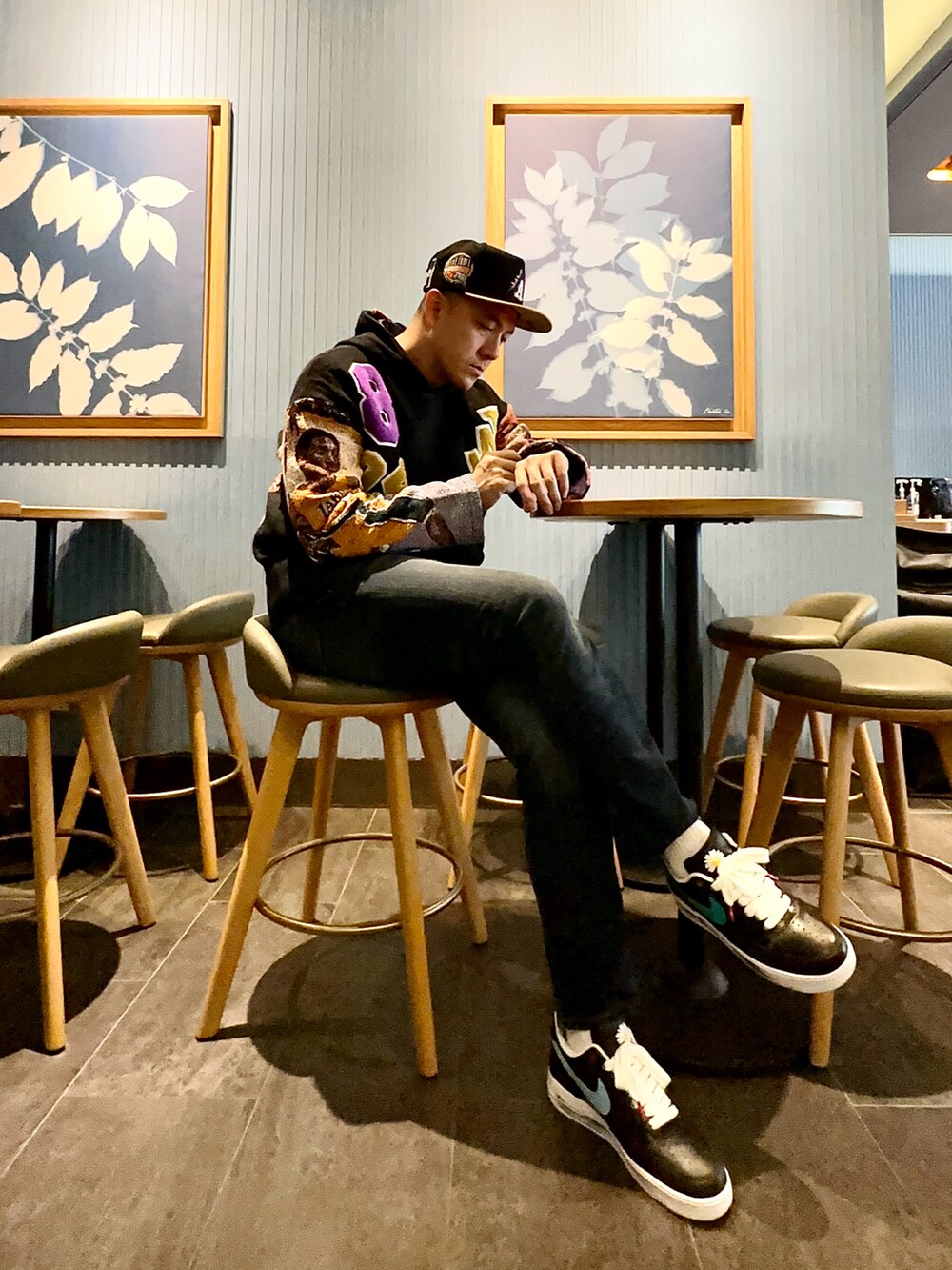 ブラック系のパーカー、ブラック系のスニーカー、ブルー系のデニムパンツを着用したメンズの冬コーディネートの2枚目の写真