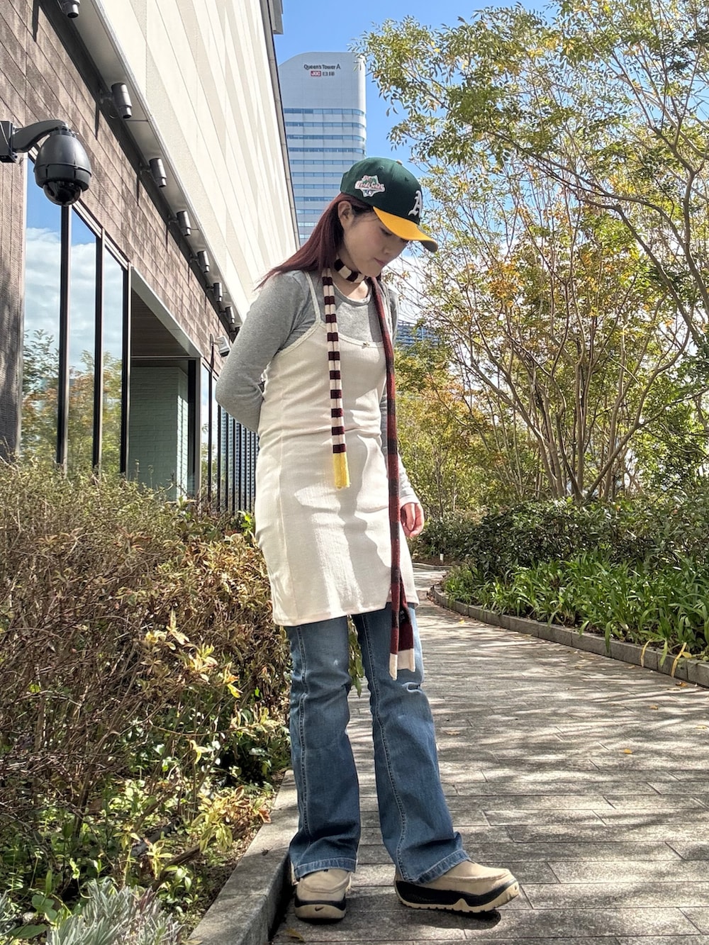 グリーン系のキャップを着用したレディースの春コーディネートの3枚目の写真