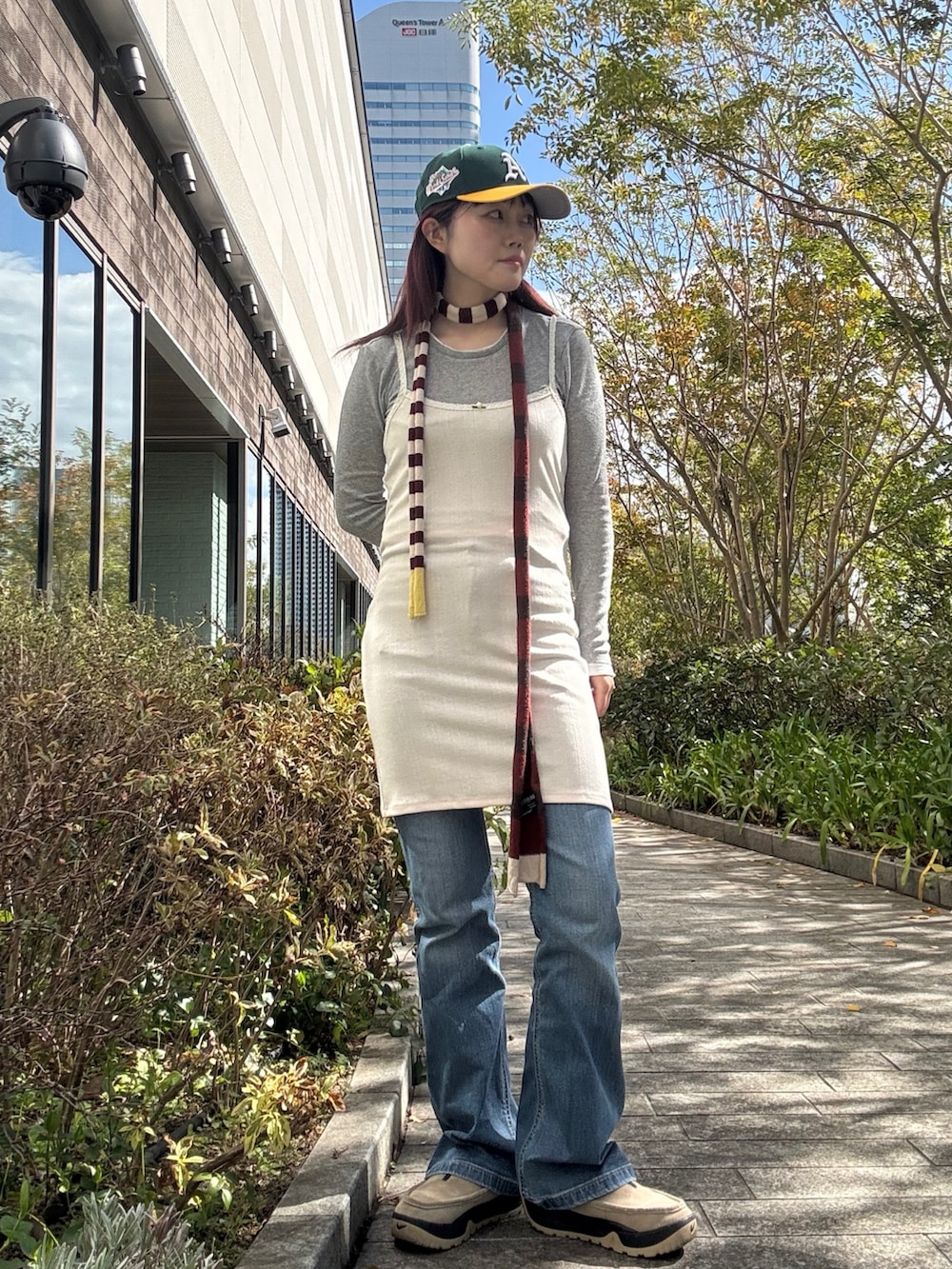 グリーン系のキャップを着用したレディースの春コーディネートの2枚目の写真