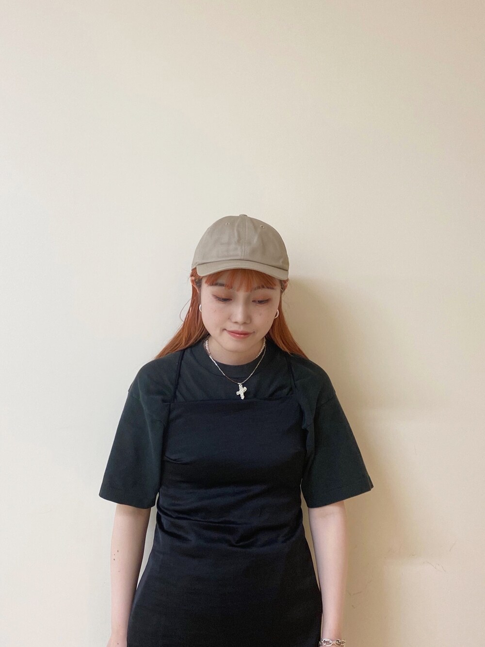 ホワイト系のスニーカー、ベージュ系のキャップを着用したレディースの夏コーディネートの2枚目の写真