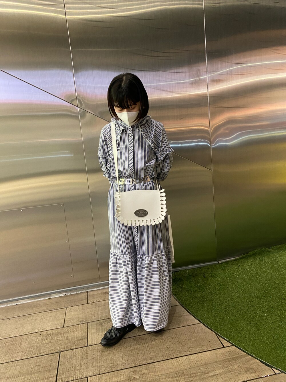 ブルー系のワンピース、ホワイト系のショルダーバッグ、ブラック系のパンプスを着用したレディースの秋コーディネートの2枚目の写真