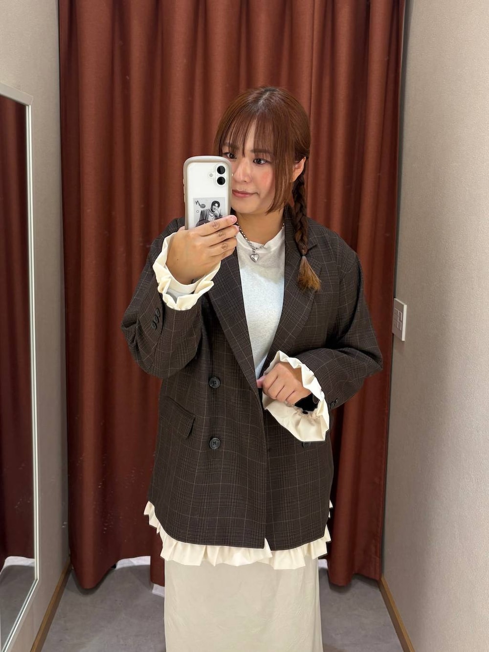 ホワイト系のスカート、ホワイト系のTシャツ/カットソー、ブラウン系のローファーを着用したレディースの秋コーディネートの3枚目の写真