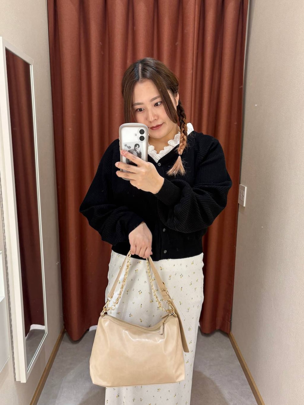 ホワイト系のスカート、ベージュ系のショルダーバッグ、ブラック系のパンプスを着用したレディースの冬コーディネートの3枚目の写真