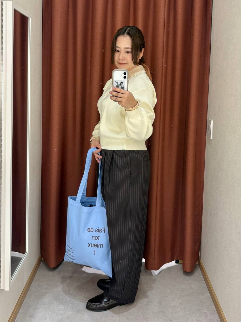 ブラウン系のその他パンツ、ホワイト系のニット/セーター、ブルー系のトートバッグを着用したレディースの冬コーディネートの2枚目の写真