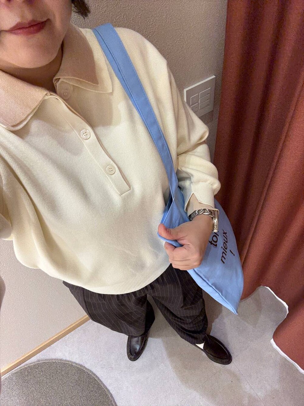 ブラウン系のその他パンツ、ホワイト系のニット/セーター、ブルー系のトートバッグを着用したレディースの冬コーディネートの4枚目の写真