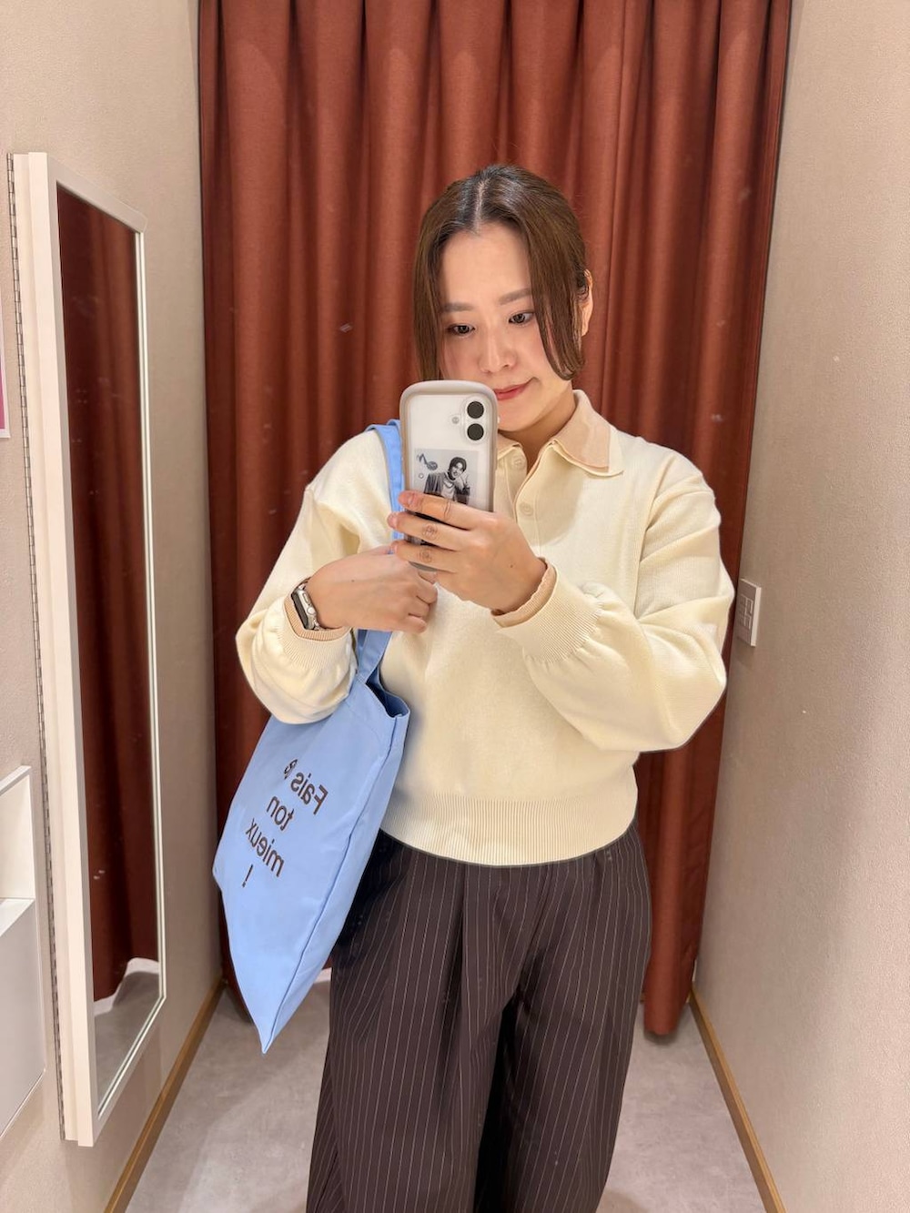 ブラウン系のその他パンツ、ホワイト系のニット/セーター、ブルー系のトートバッグを着用したレディースの冬コーディネートの3枚目の写真