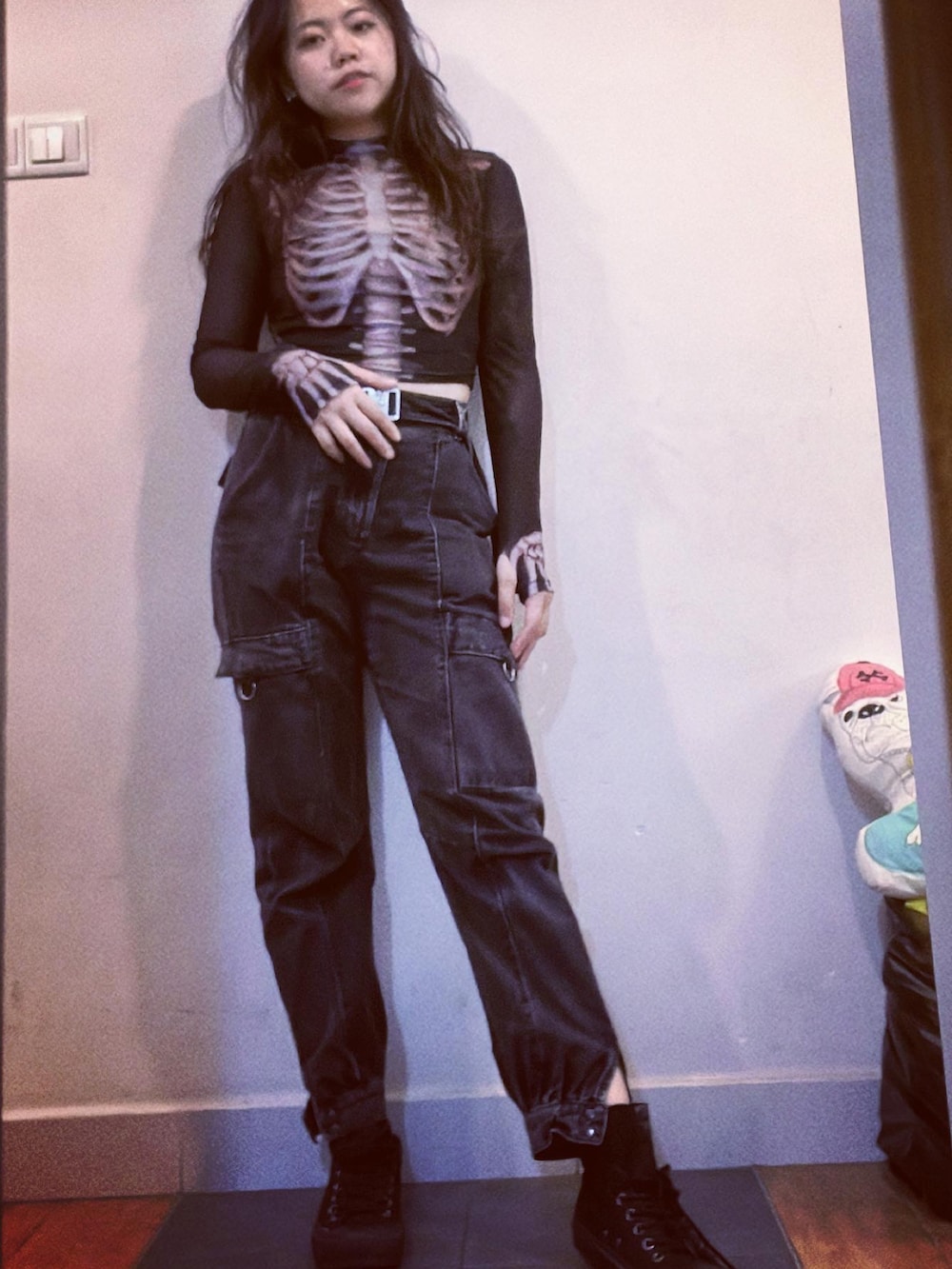 ブラック系のデニムパンツ、ブラック系のトップス、ブラック系の手袋を着用したレディースの春コーディネートの4枚目の写真