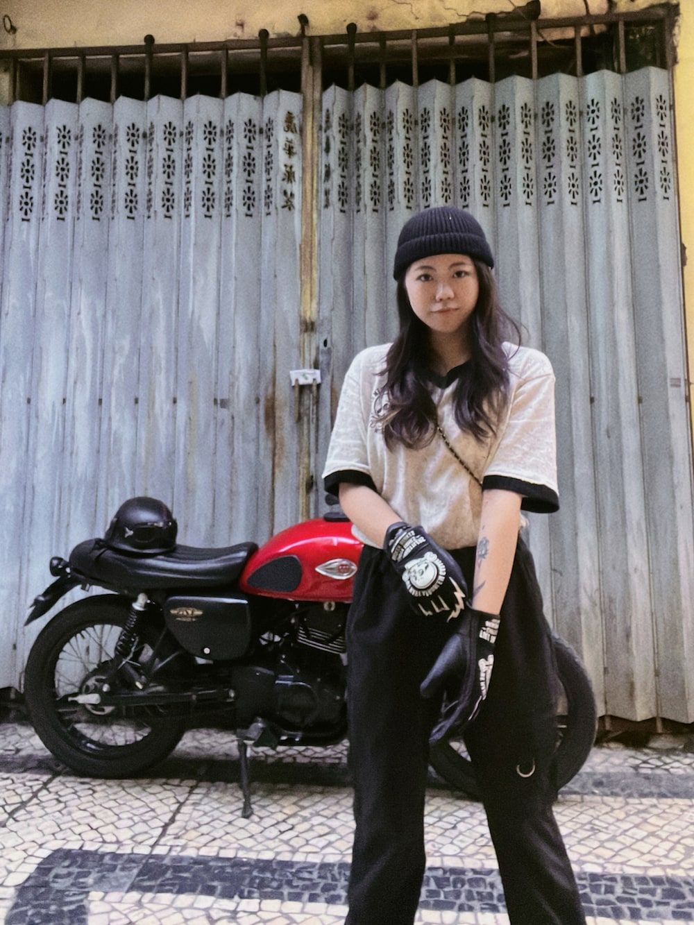 ホワイト系のTシャツ/カットソー、ブラック系のチノパンツ、ブラック系のスニーカーを着用したレディースの春コーディネートの2枚目の写真