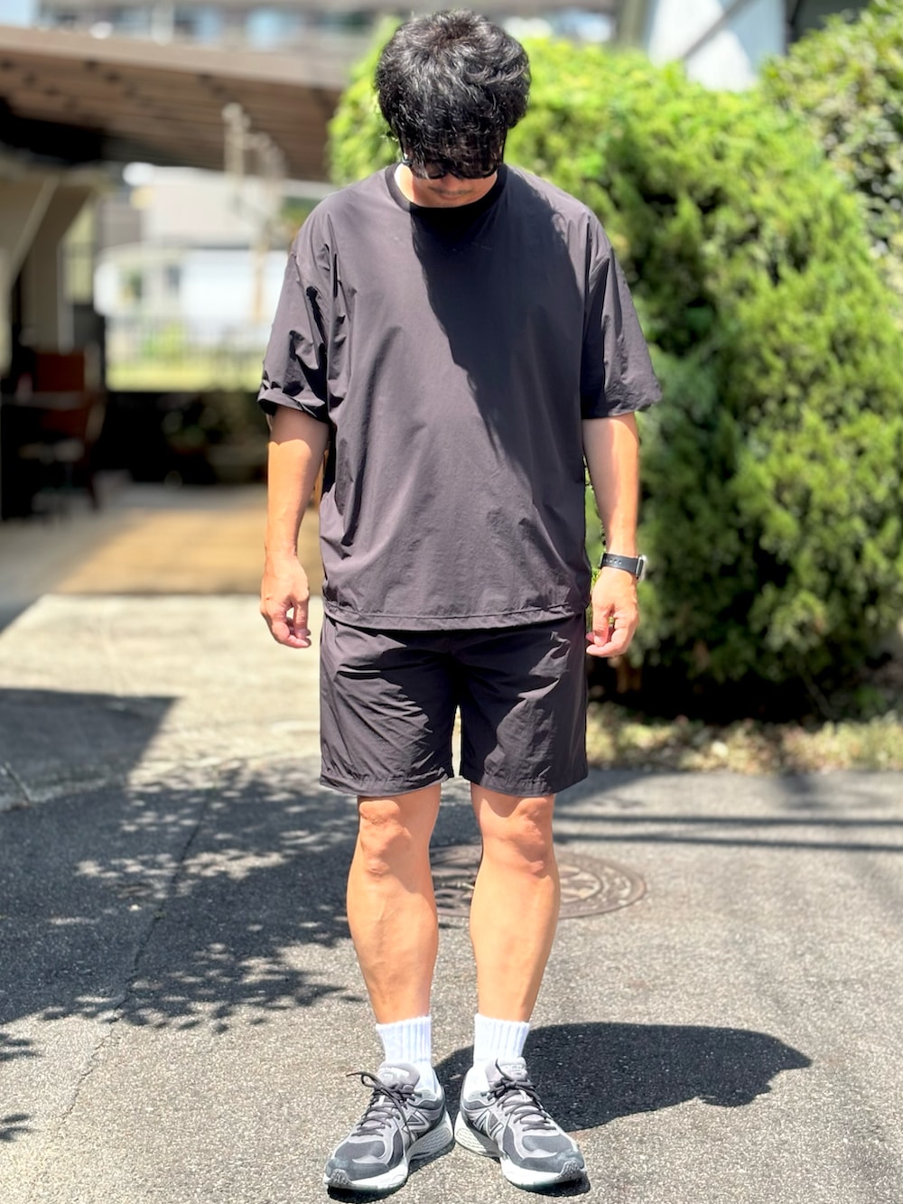 ブラック系のその他パンツ、ブルー系のTシャツ/カットソー、ブラック系のスニーカーを着用したメンズの夏コーディネートの2枚目の写真