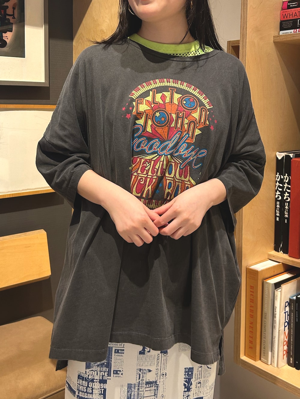 ブラック系のTシャツ/カットソー、ブルー系のスカート、グリーン系のTシャツ/カットソーを着用したレディースの春コーディネートの2枚目の写真