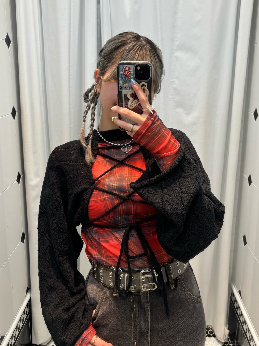 ブラック系のデニムパンツ、レッド系のワンピース、ブラック系のニット/セーターを着用したレディースの夏コーディネートの2枚目の写真