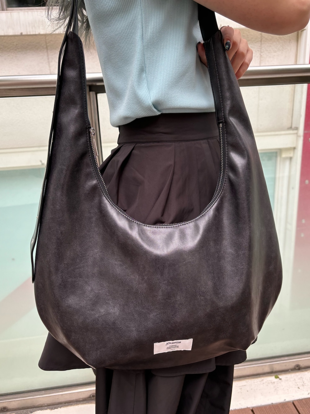 ブラック系のスカート、ブラック系のその他シューズ、ブラック系のショルダーバッグを着用したレディースの春コーディネートの8枚目の写真