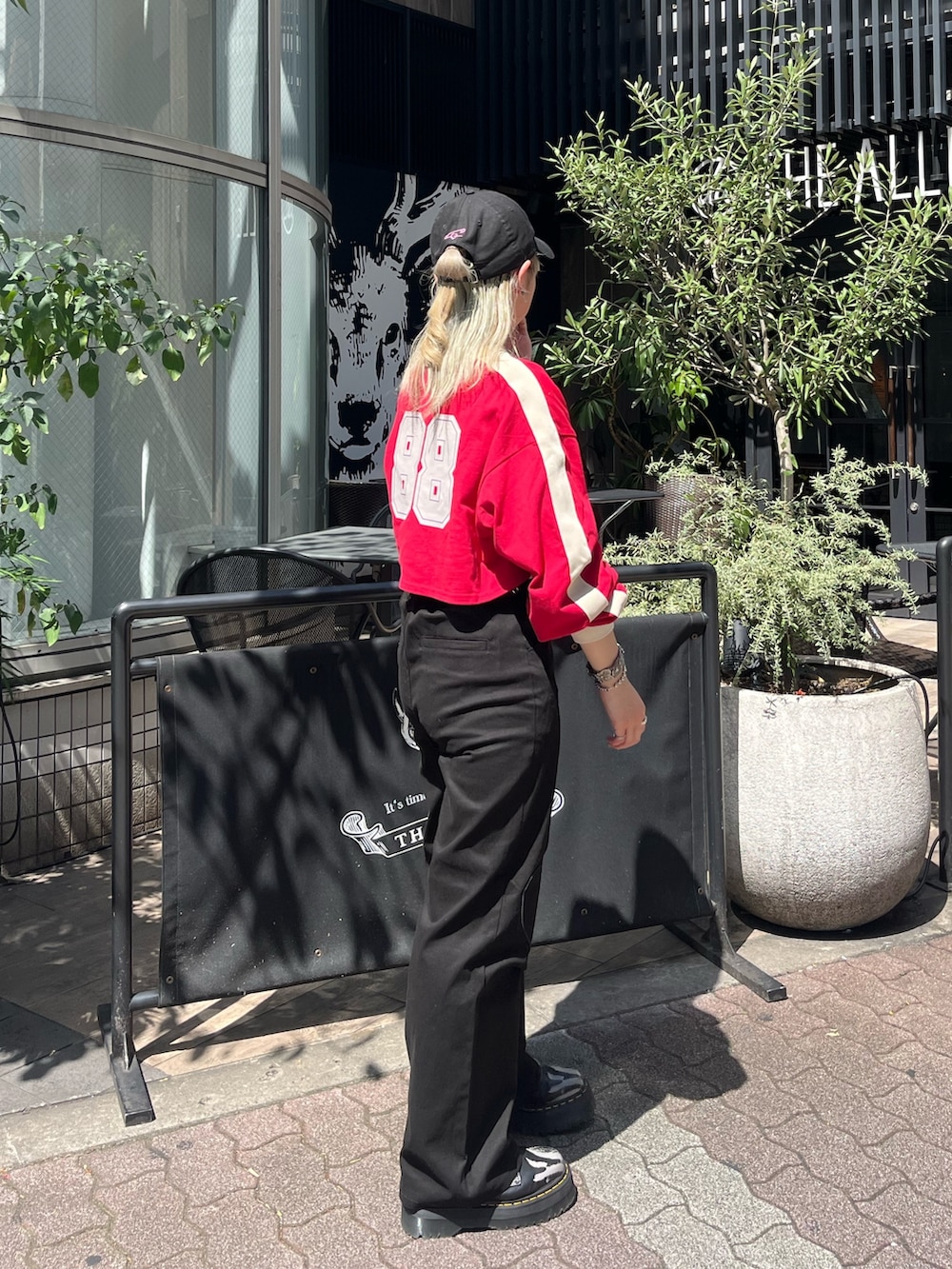 ブラック系のその他パンツ、レッド系のTシャツ/カットソー、シルバー系のネックレスを着用したレディースの秋コーディネートの2枚目の写真