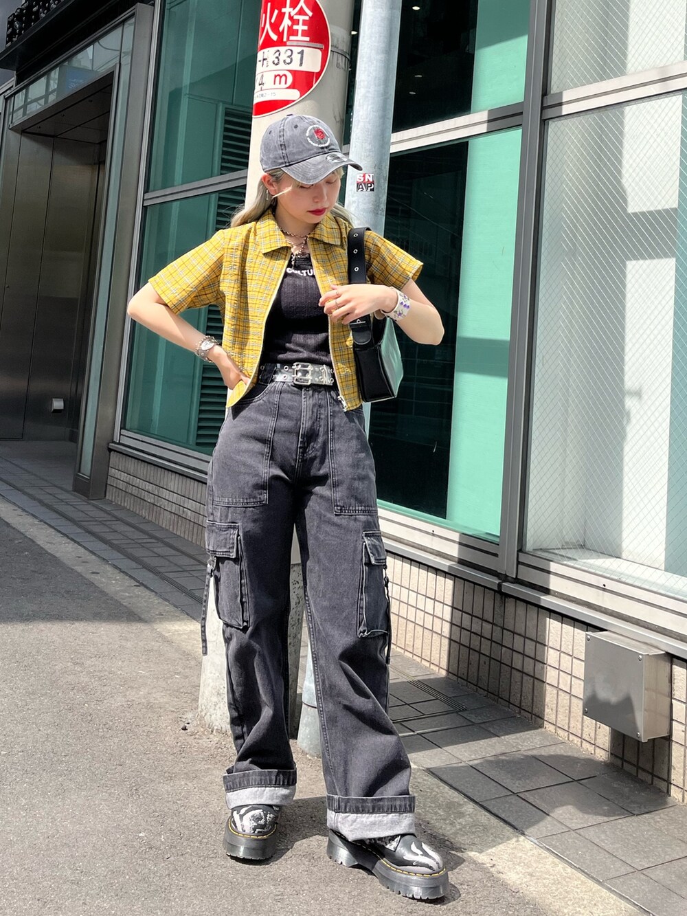 ブラック系のハンドバッグ、ブラック系のカーゴパンツ、ブラック系のタンクトップを着用したレディースの春コーディネートの2枚目の写真