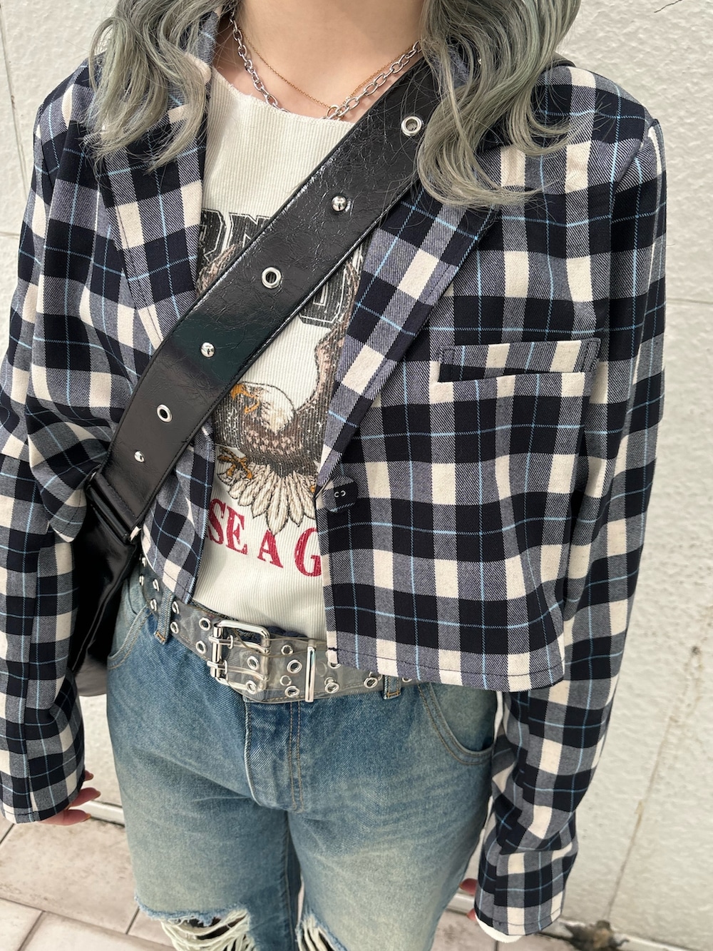 ブルー系のデニムパンツ、ブラック系のショルダーバッグ、ホワイト系のTシャツ/カットソーを着用したレディースの冬コーディネートの8枚目の写真