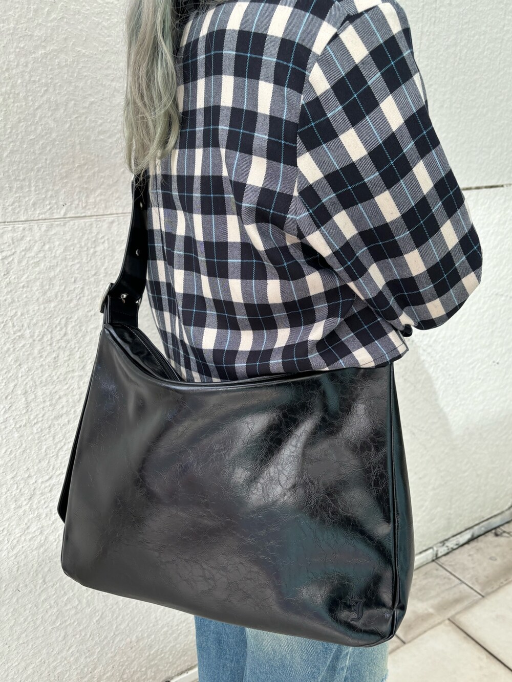 ブルー系のデニムパンツ、ブラック系のショルダーバッグ、ホワイト系のTシャツ/カットソーを着用したレディースの冬コーディネートの10枚目の写真