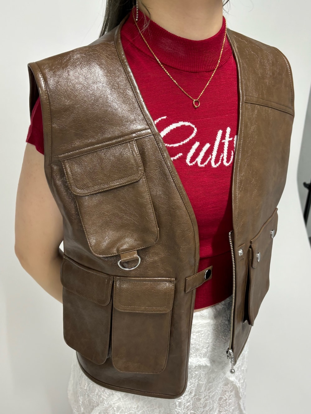 ホワイト系のその他パンツ、レッド系のニット/セーター、ブラウン系のベストを着用したレディースの春コーディネートの6枚目の写真