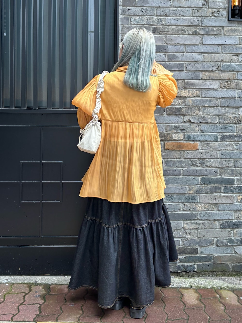 オレンジ系のシャツ/ブラウス、ホワイト系のTシャツ/カットソー、ホワイト系のショルダーバッグを着用したレディースの春コーディネートの3枚目の写真