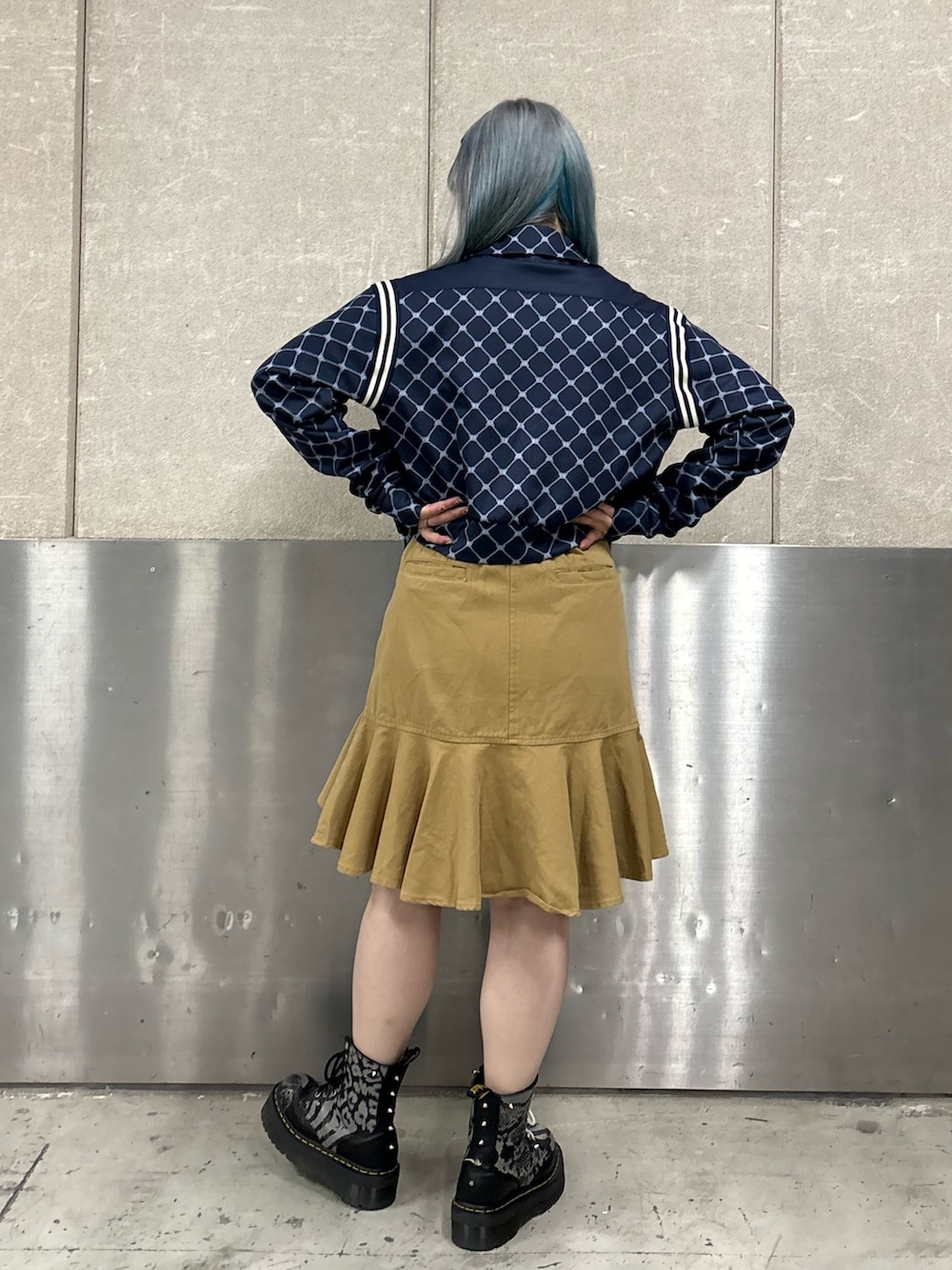 ベージュ系のスカート、ピンク系のニット/セーター、ブルー系のジャージを着用したレディースの春コーディネートの2枚目の写真