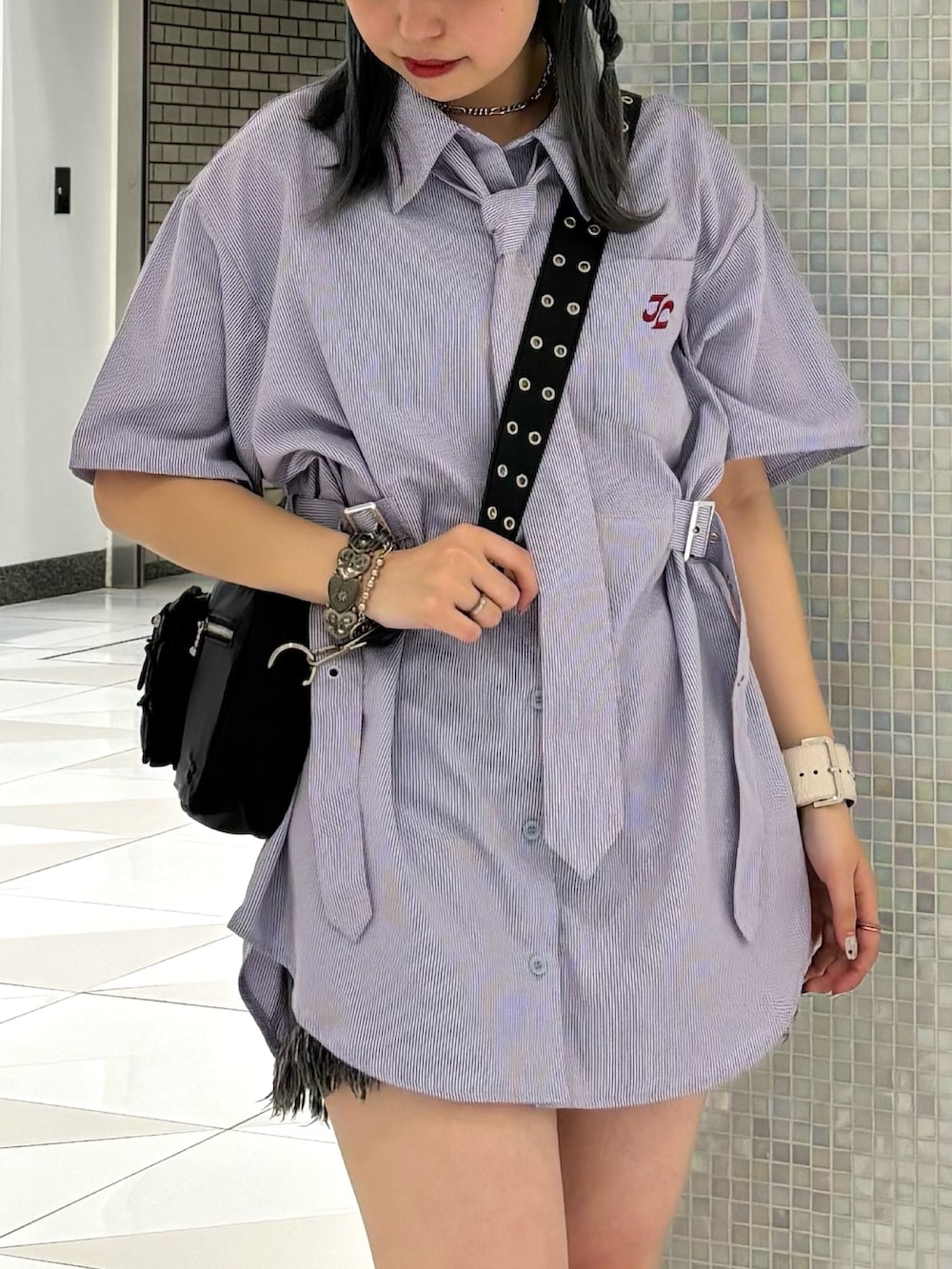 ブラック系のデニムパンツ、ブラック系のショルダーバッグ、パープル系のシャツ/ブラウスを着用したレディースの夏コーディネートの5枚目の写真