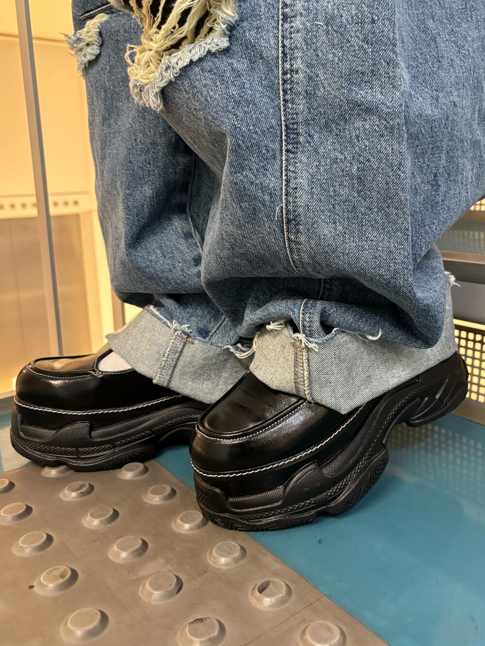 ブラック系のトートバッグ、ブルー系のデニムパンツ、ブルー系のデニムパンツを着用したレディースの春コーディネートの8枚目の写真