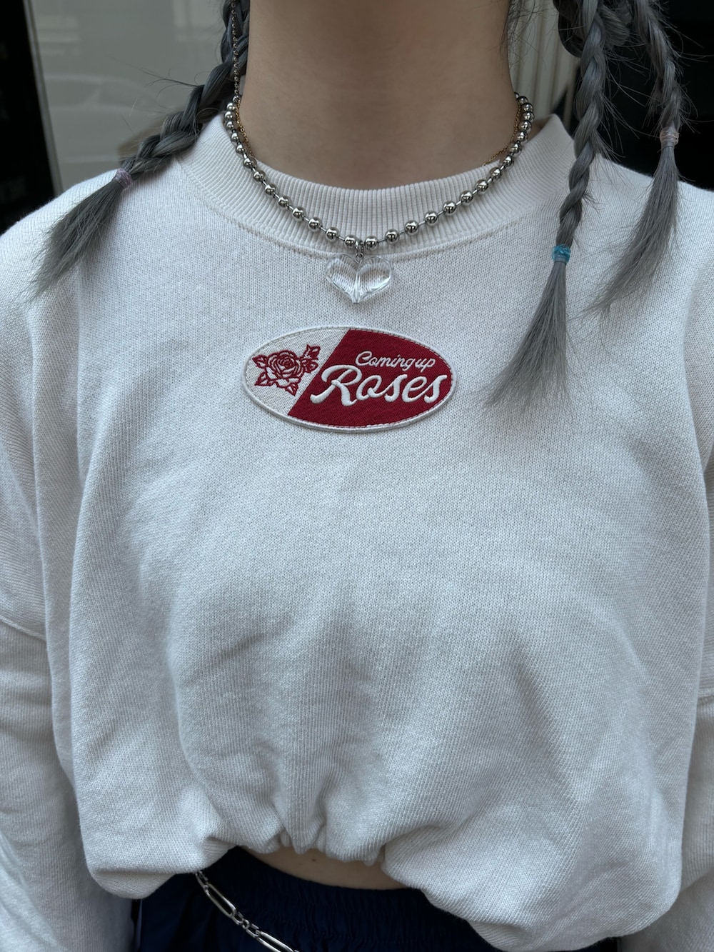 ブルー系のスカート、ホワイト系のスウェット、シルバー系のベルトを着用したレディースの夏コーディネートの5枚目の写真